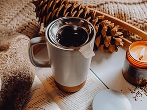 a woman holding her mug as the tea is brewing inside