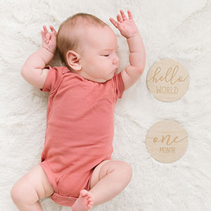 Baby laying next to photo sharing discs